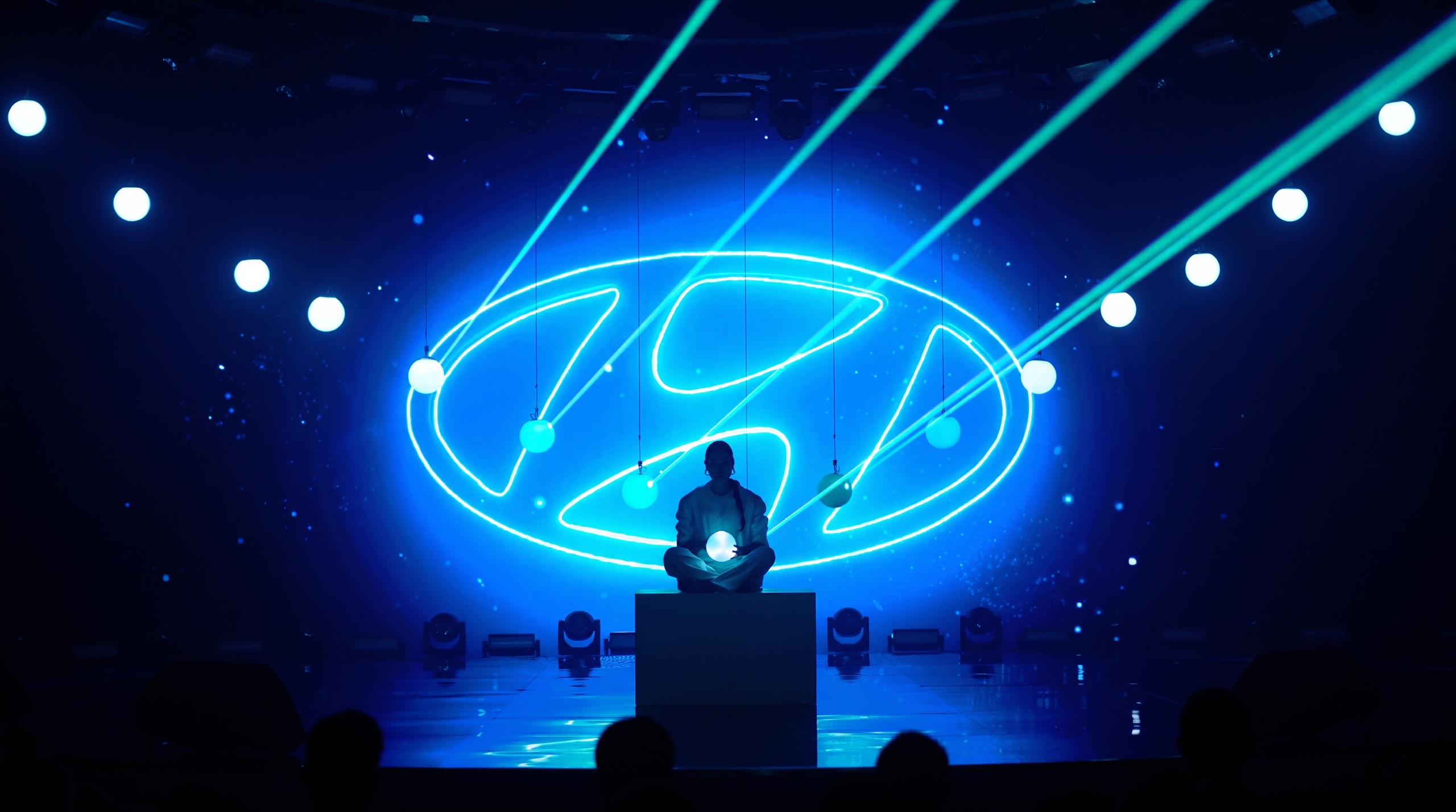 A single silhouette, a neon mark and the beams — the stage Gubsky Talent Hub built.
