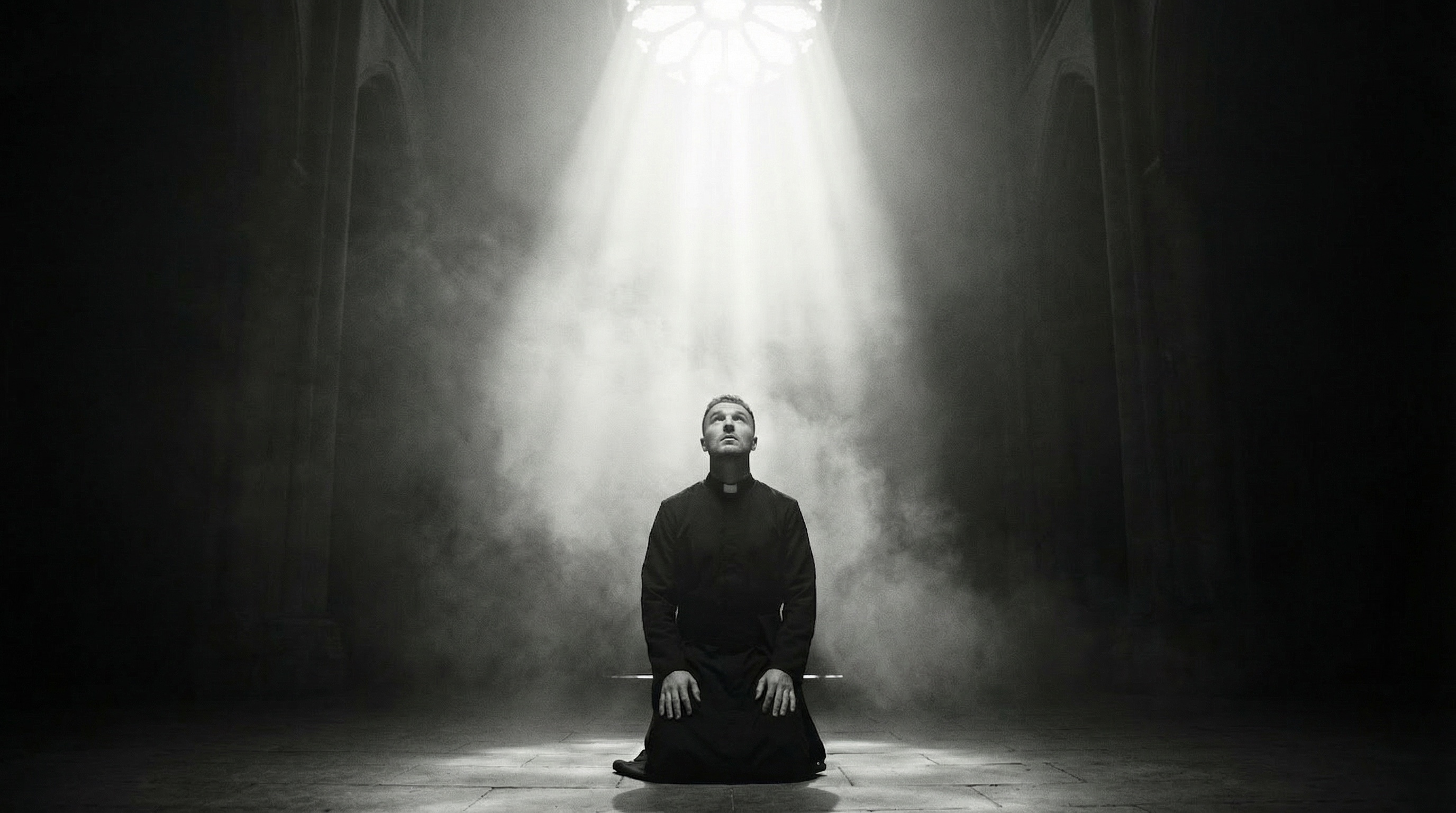 On his knees under the rose window, in a single shaft of light