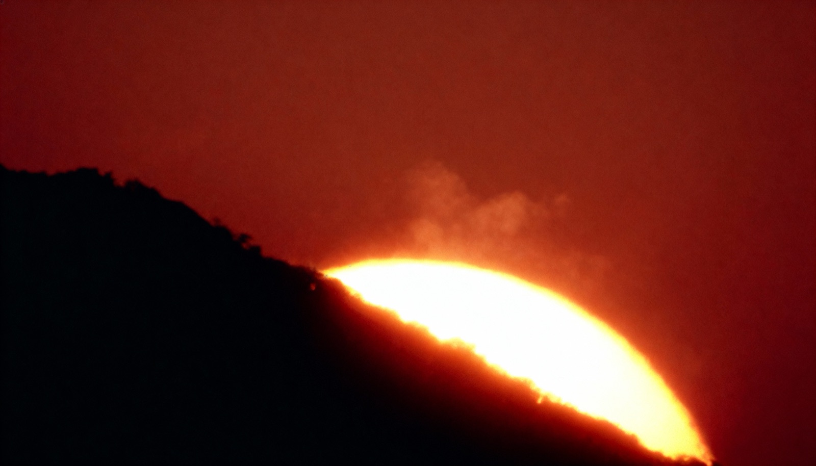 The sun behind the ridge — the film’s opening register